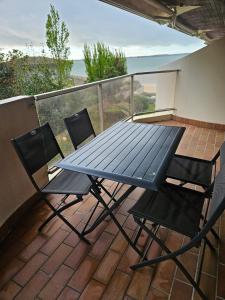 a picnic table and two chairs on a balcony at Plage Pereire Arcachon vue sur mer in Arcachon