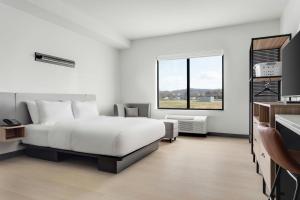 a white bedroom with a bed and a window at StudioRes by Marriott Jackson, TN in Jackson