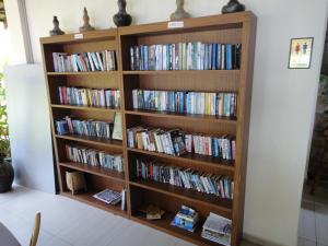 een boekenplank gevuld met boeken en dvd's bij Minang Cove Resort in Tioman Island