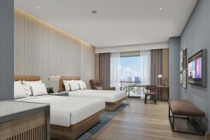 a hotel room with two beds and a television at Four Points by Sheraton Jinan, High-Tech Zone in Jinan +62 photos