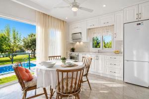 a kitchen with a table with chairs and a refrigerator at Villa Riva in Oludeniz