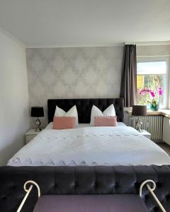 a bedroom with a large bed with pink pillows at Apartment in Flensburg