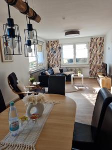 a living room with a table and a couch at Ferienwohnung Am Brombachtal in Simmerath +8 photos