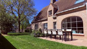 a table and chairs in front of a house at Villa Oni met grote speelruimte in Koksijde