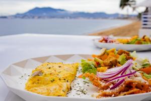 a plate of food on a table with a salad at Best Western Plus Luna del Mar in Manzanillo
