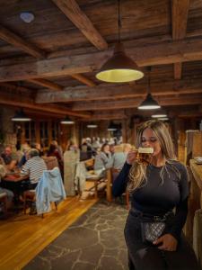 a woman drinking a glass of wine in a restaurant at Berry in Klatovy