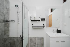 a white bathroom with a shower and a sink at Apartman Mimi - Pula airport in Pula +23 photos