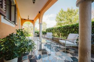 an outdoor patio with chairs and a table and plants at Apartman Mimi - Pula airport in Pula