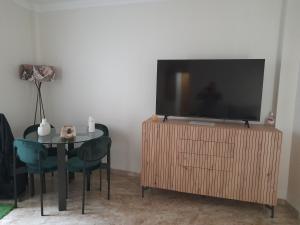 a living room with a television and a table with chairs at Atelier de lujo lucena in Lucena