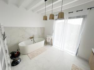a white bathroom with a tub and a window at Villa ROYA in Saint-Florent +29 photos