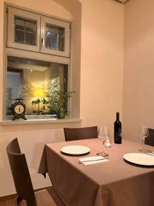 a table with two chairs and a window with a clock at Monopatia Resort in Ano Pedina
