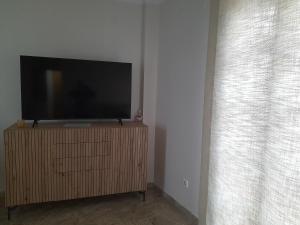 a flat screen tv sitting on a stand next to a window at Atelier de lujo lucena in Lucena +10 photos