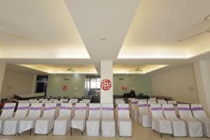 a room with rows of white chairs and a room with at Mangalam Hotel and Restaurant in Lachhmangarh Sīkar