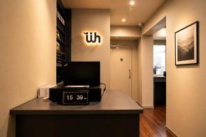 an office with a clock and a sign on a counter at Wink at McCallum Street in Singapore