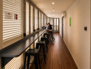 a long hallway with stools and a row of windows at Wink at McCallum Street in Singapore