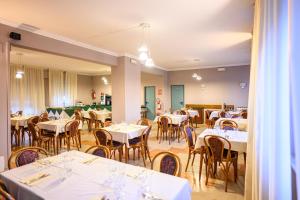 a dining room with white tables and chairs at Hotel Laurin in Lido di Camaiore +32 photos