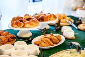 a table with plates of croissants and other pastries at Hotel Laurin in Lido di Camaiore
