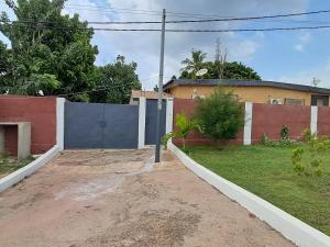 a house with a blue fence and a yard at 2 CHAMBRES SALON MEUBLé in Yamoussoukro