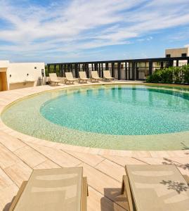 a large swimming pool with lounge chairs on a building at Tuk Hacienda Studio Rooftop Pool Padel TUK in Tulum
