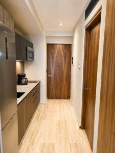 a kitchen with a wooden door and a wooden floor at Tuk Hacienda Studio Rooftop Pool Padel TUK in Tulum