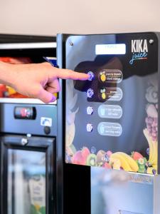 a hand pointing at the door of a refrigerator at Hotel Laurin in Lido di Camaiore