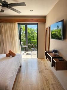 a bedroom with a bed and a view of a balcony at Tuk Hacienda Studio Rooftop Pool Padel TUK in Tulum