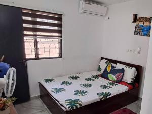 a small bed in a room with a window at 2 CHAMBRES SALON MEUBLé in Yamoussoukro