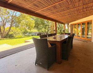 a wooden table and chairs on a patio at Franschhoek farm off the grid in Franschhoek