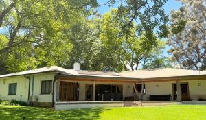 an old white house with trees in the background at Franschhoek farm off the grid in Franschhoek