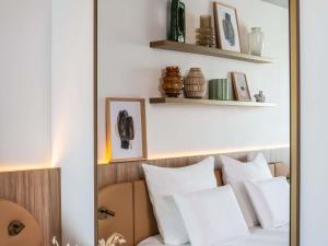a mirror over a bed with white pillows at Pullman Lyon in Lyon +79 photos