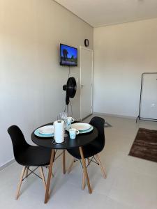 a table and chairs in a room with a white wall at 04 Studios centro,proximo a rodoviaria-itapeva sp in Itapeva