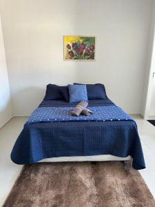 a blue bed with a blue comforter and shoes on it at 04 Studios centro,proximo a rodoviaria-itapeva sp in Itapeva