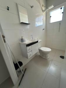a white bathroom with a sink and a toilet at 04 Studios centro,proximo a rodoviaria-itapeva sp in Itapeva
