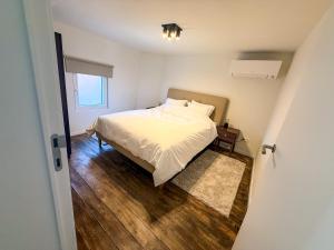 a bedroom with a bed with white sheets and a window at Vakantiewoning Goed Thuis in Dilsen-Stokkem