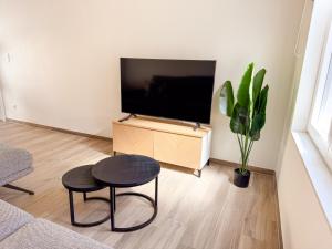 a living room with a television and a table and stool at Vakantiewoning Goed Thuis in Dilsen-Stokkem