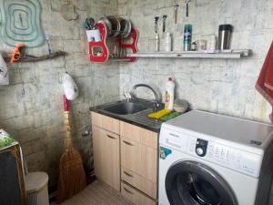 a kitchen with a washing machine and a sink at Enjoy Georgian Regions in Tʼetʼri Tsqaro