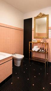 a bathroom with a sink and a toilet and a mirror at Maison 10 personnes 4 chambre 2 sdb in Liourdres