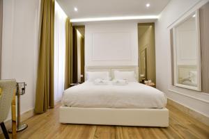 a bedroom with a white bed with two towels on it at Domus De Cinti Charme Rooms in Tivoli +11 photos