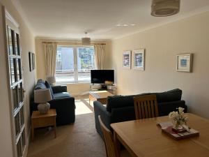 a living room with a couch and a table at 1/5 Lismore House in Oban