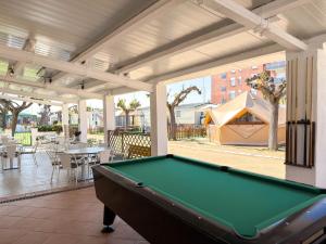 a pool table on a patio with a tent at Camping Costa Dorada Bungalow Maia in Canet de Mar