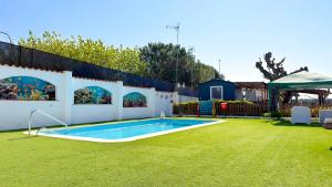 a swimming pool in a backyard with a grass yard at Camping Costa Dorada Bungalow Maia in Canet de Mar