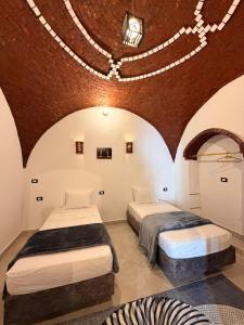 two beds in a room with a brick wall at Oriental house in Luxor +21 photos