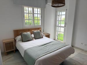a bedroom with a bed with two pillows and two windows at Villa del Mar in Torremolinos +32 photos