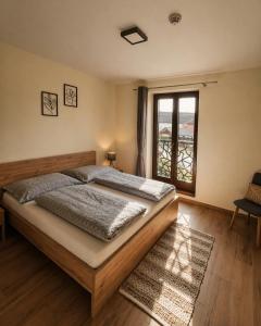 a bedroom with a large bed and a window at Apartmány Zaky in Vrbov