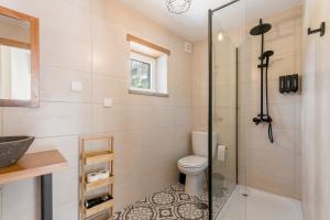 a bathroom with a shower and a toilet at StoneBridge Riverside Mountain Apartments in Loriga