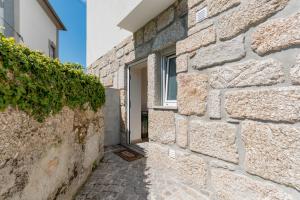 a stone wall with a window in a building at StoneBridge Riverside Mountain Apartments in Loriga
