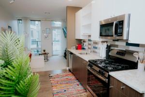 a kitchen with a stove and a counter top at Luxury 2BR Apartment with Pool, Balcony & Parking in Cambridge
