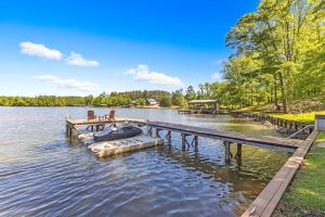 a dock on a lake with a boat in the water at Abigail's Lake Haven in Jacksons Gap