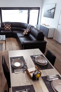a living room with a table and a leather couch at Laurina's Cove in Ostend