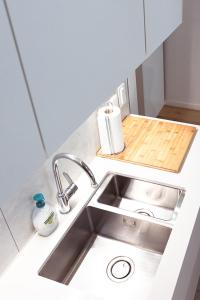 a kitchen counter with a sink and a cutting board at Laurina's Cove in Ostend +43 photos